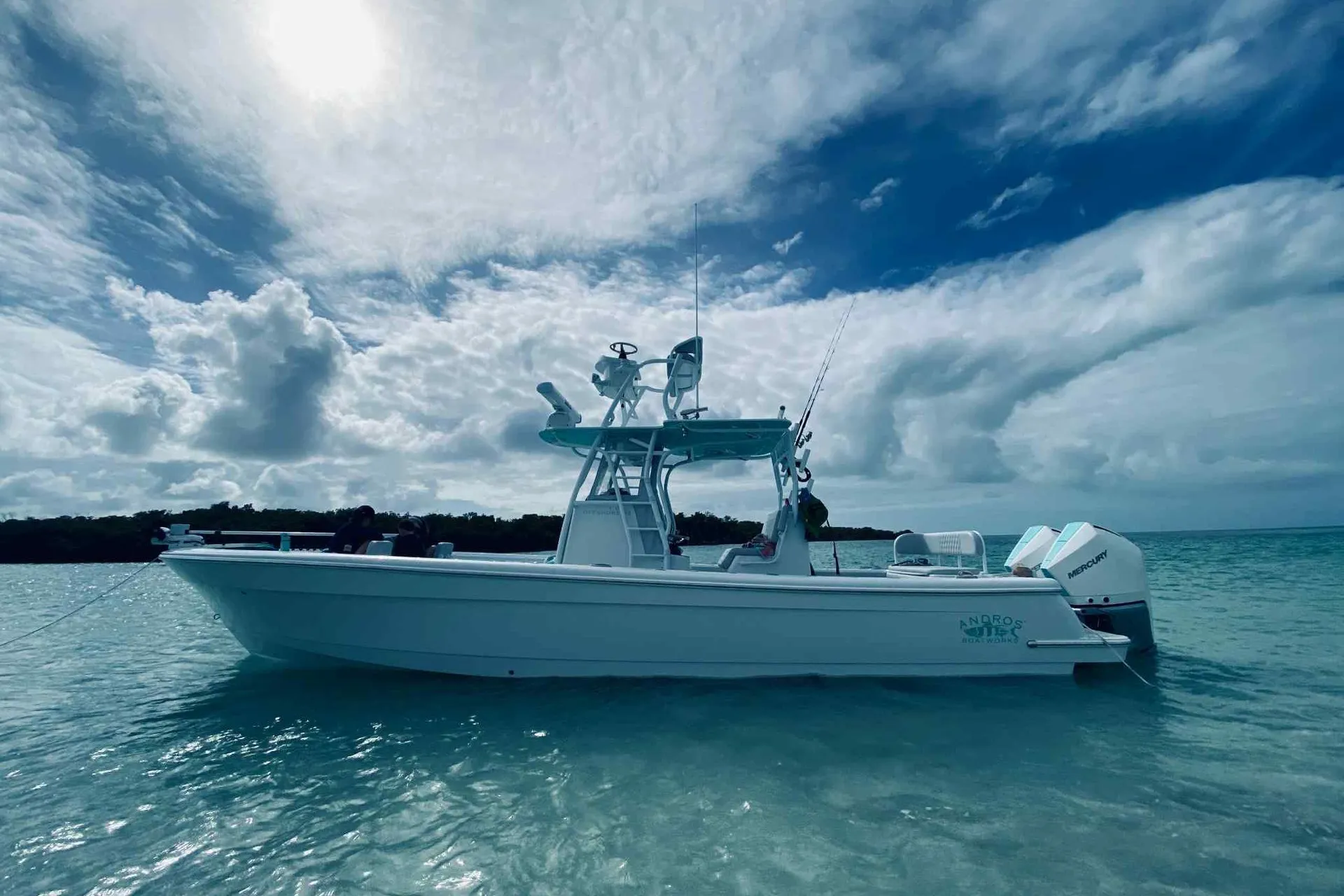 2023 Andros Offshore 32 boat on clear water under a cloudy sky.